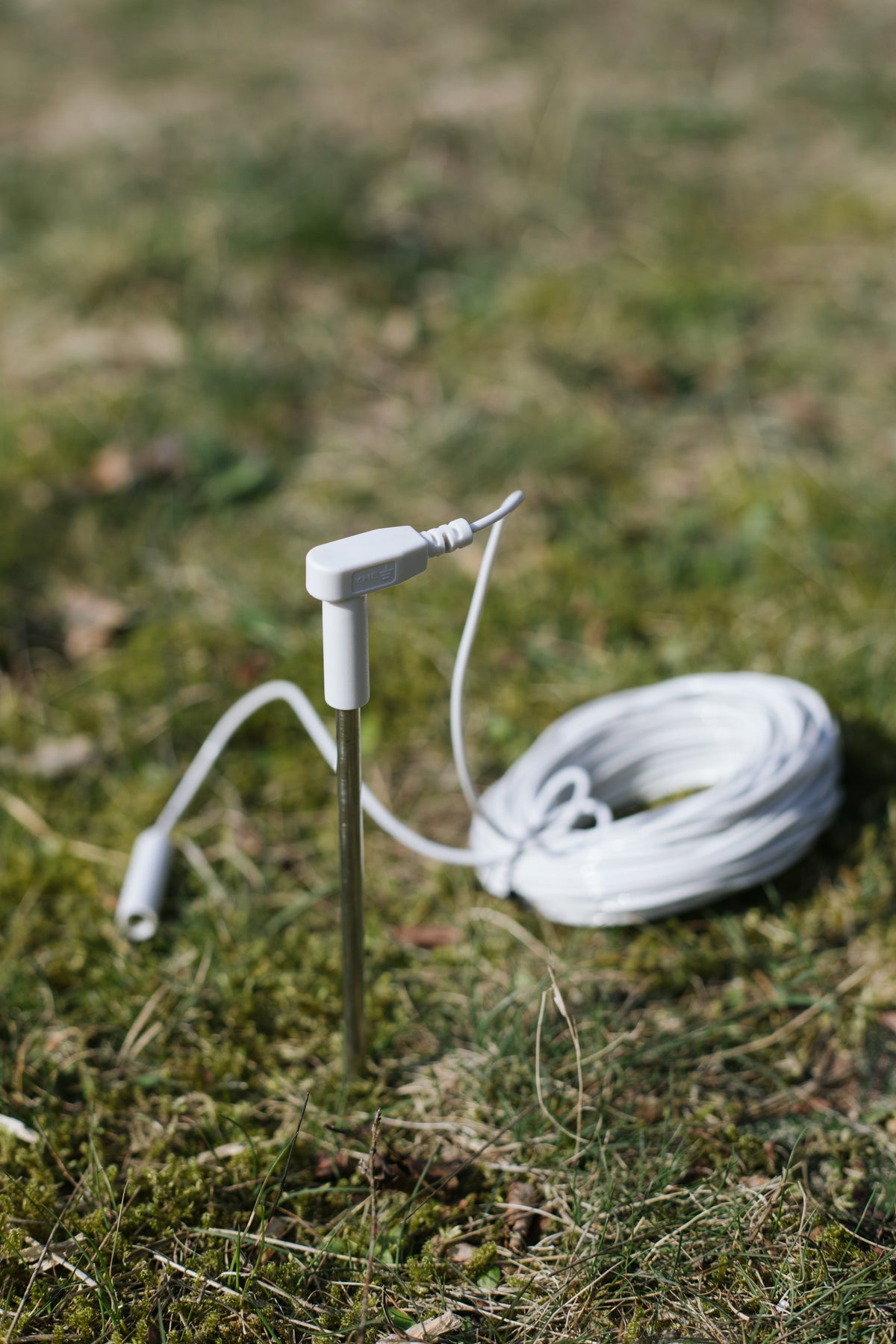 Earthle jordspyd i jorden med det oprullede kabel ved siden af